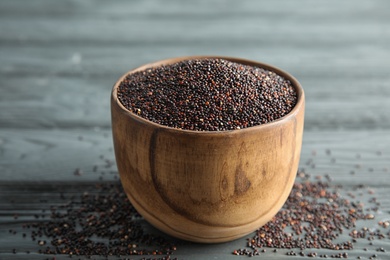 Photo of Bowl with black quinoa on wooden table