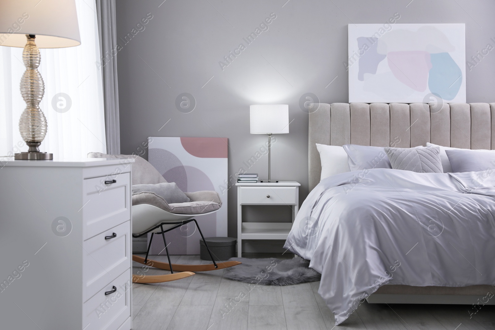 Photo of Cozy bed with soft silky bedclothes in light room