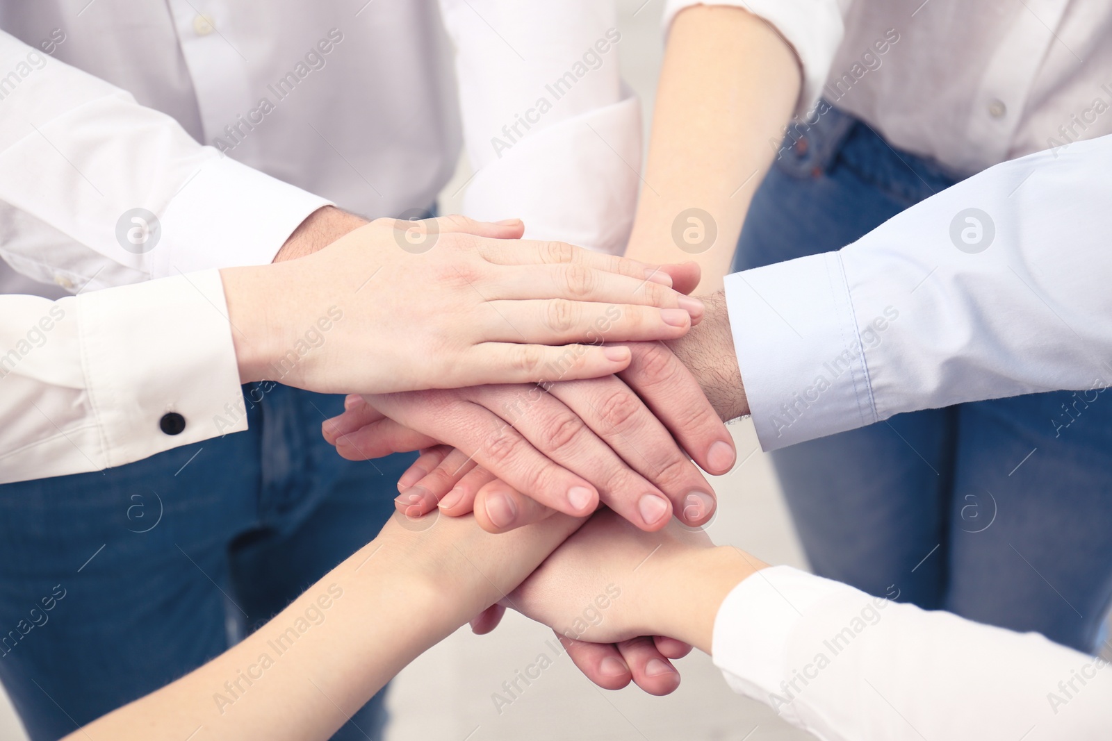 Photo of People holding hands together in office, closeup