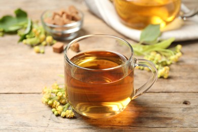 Cup of tea and linden blossom on wooden table