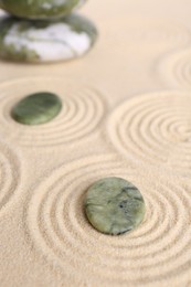 Photo of Zen garden stones on beige sand with pattern