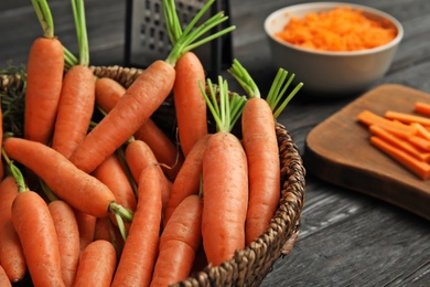 Photo of Bowl with ripe carrots on table, closeup