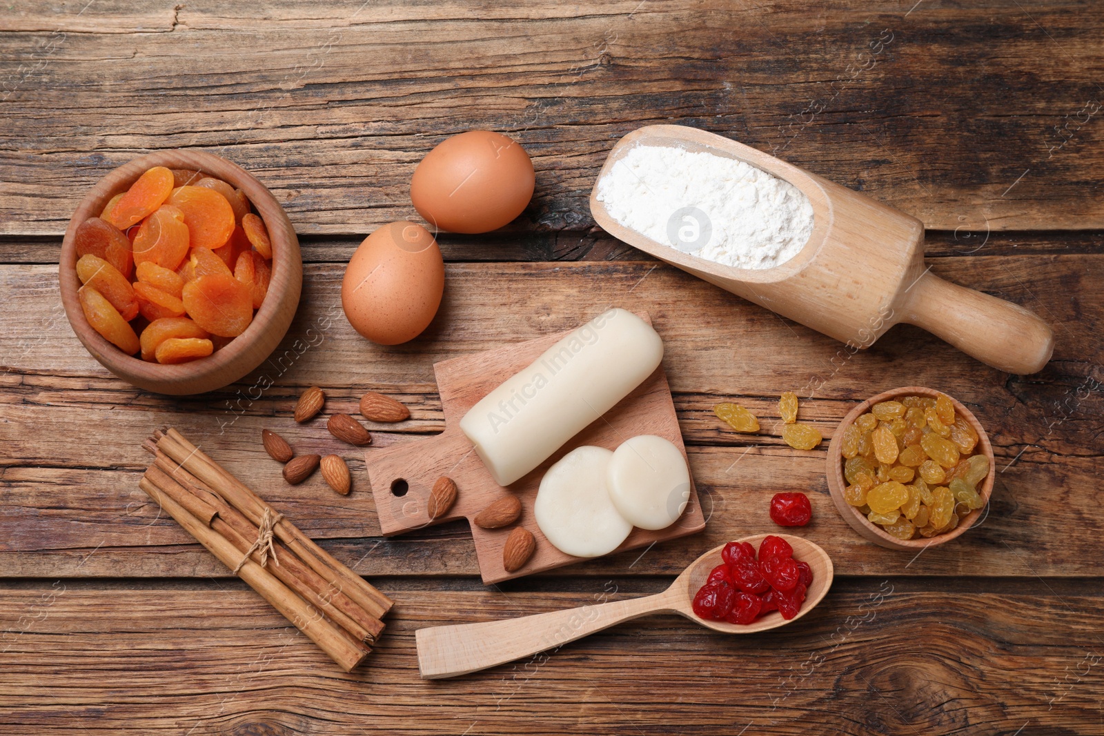 Photo of Marzipan and other ingredients for homemade Stollen on wooden table, flat lay. Baking traditional German Christmas bread