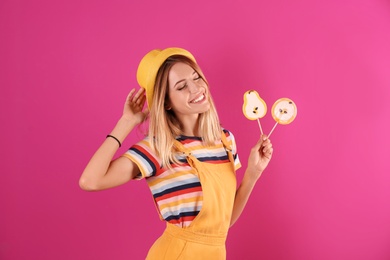 Young pretty woman with candies on colorful background