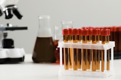 Test tubes with brown liquid on white table. Space for text