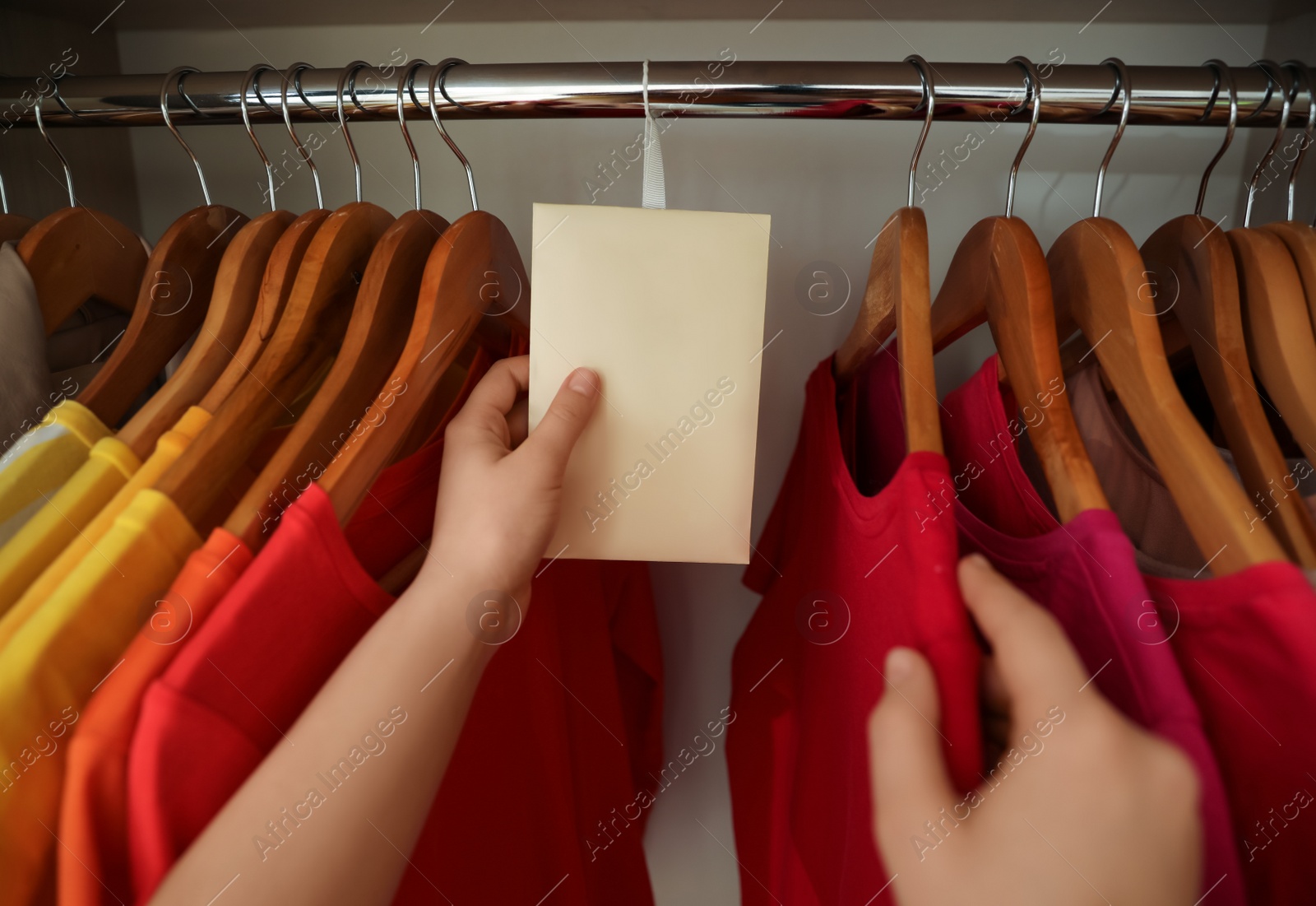 Photo of Woman putting scented sachet in wardrobe, closeup