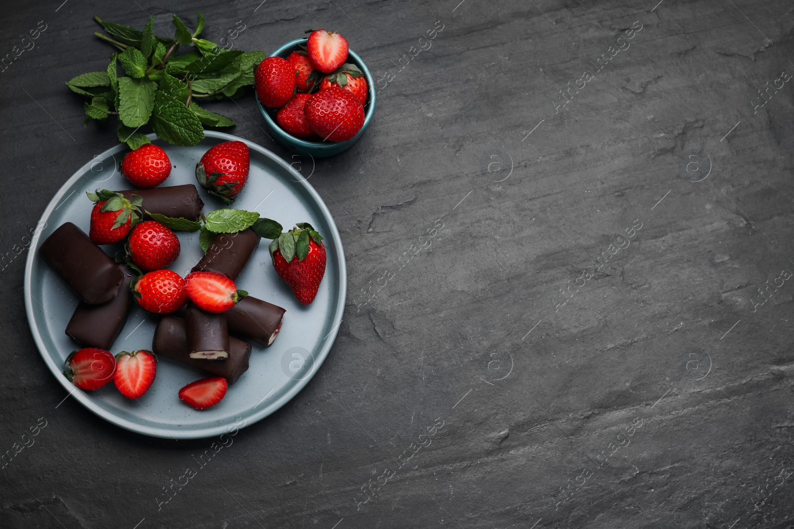 Photo of Delicious glazed curd snacks with fresh strawberries and mint on black table, flat lay. Space for text