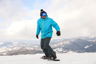 Photo of Male snowboarders on snowy hill. Winter vacation