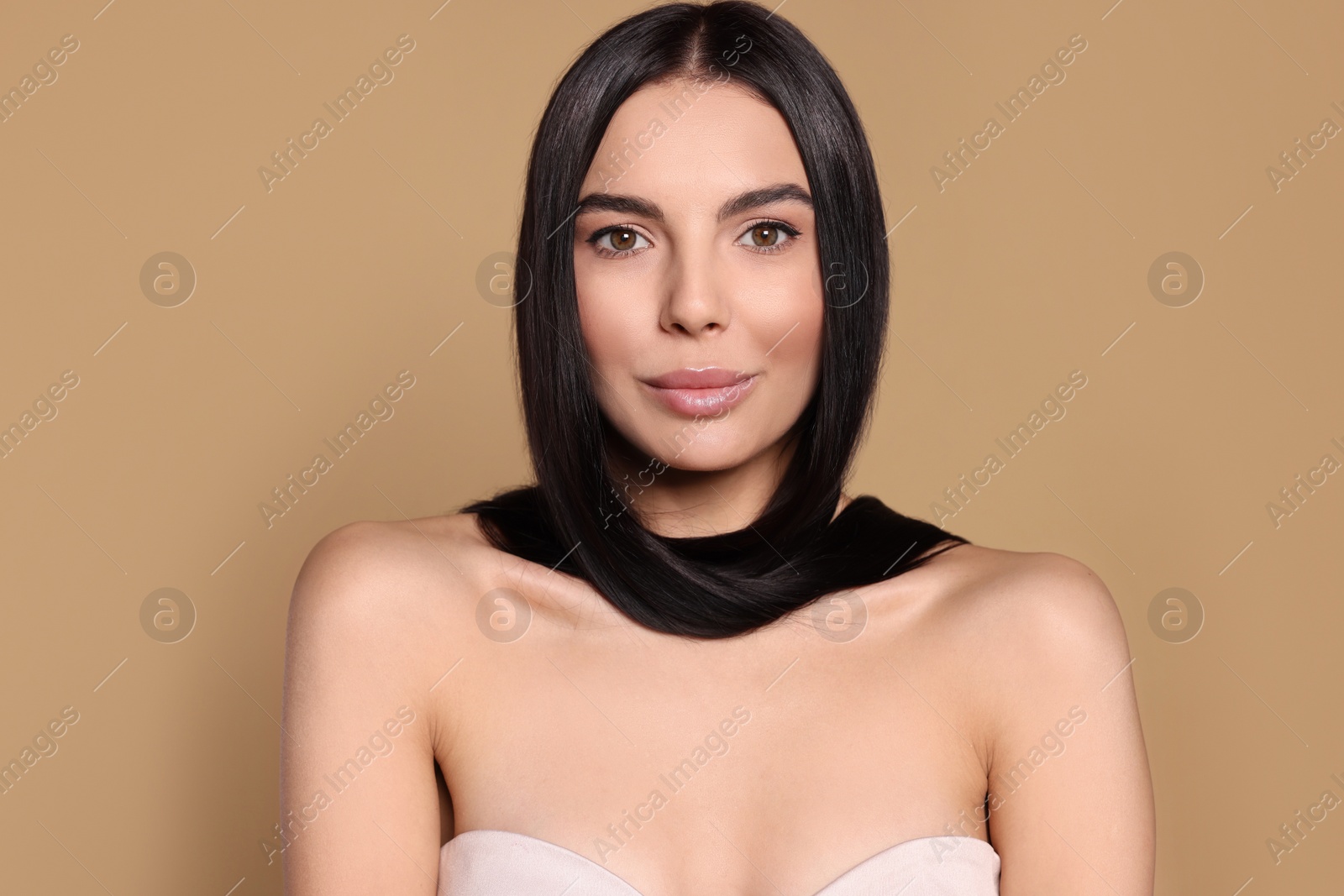 Photo of Portrait of beautiful young woman with healthy strong hair on beige background