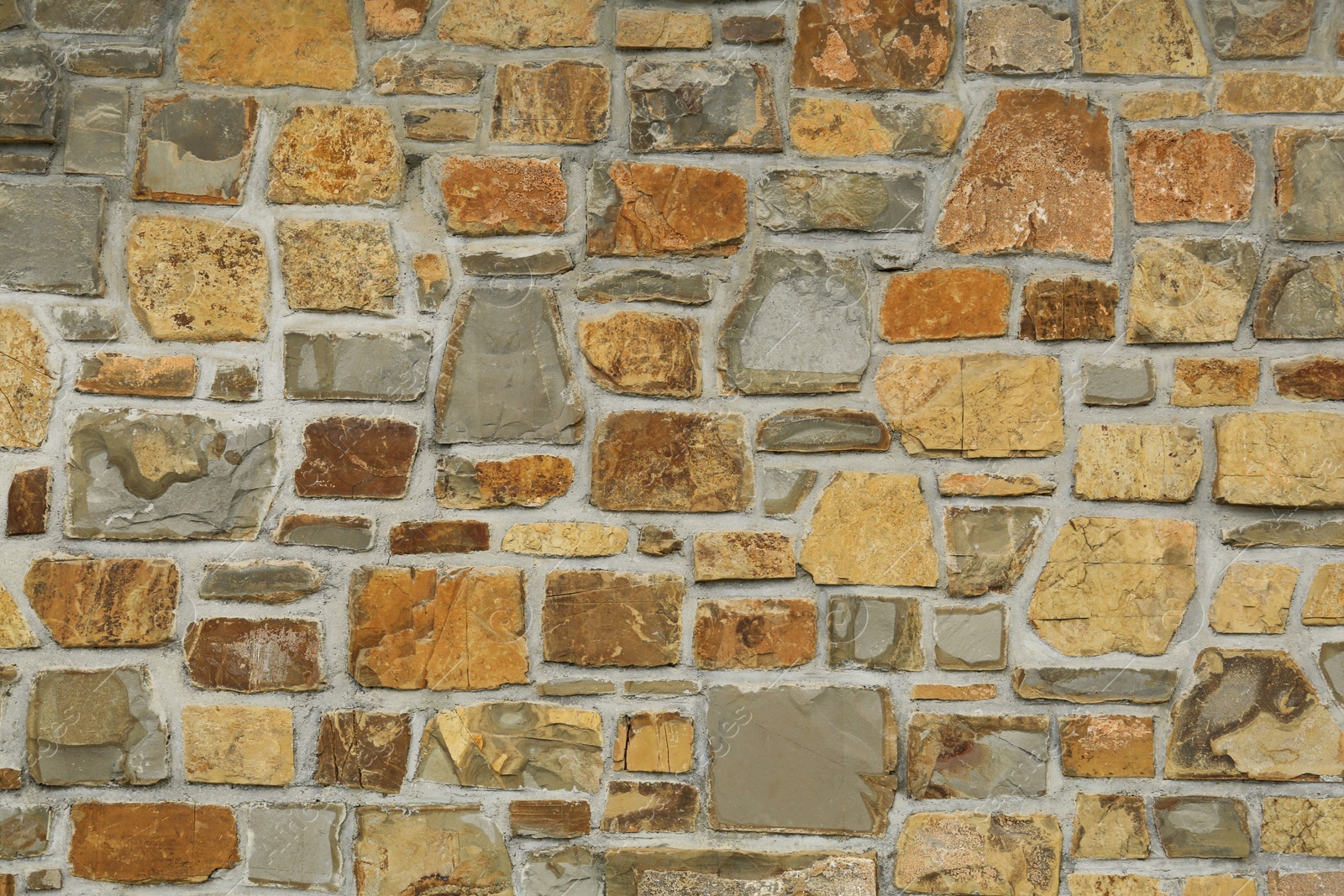 Photo of Beautiful stone wall made of bricks as background, closeup