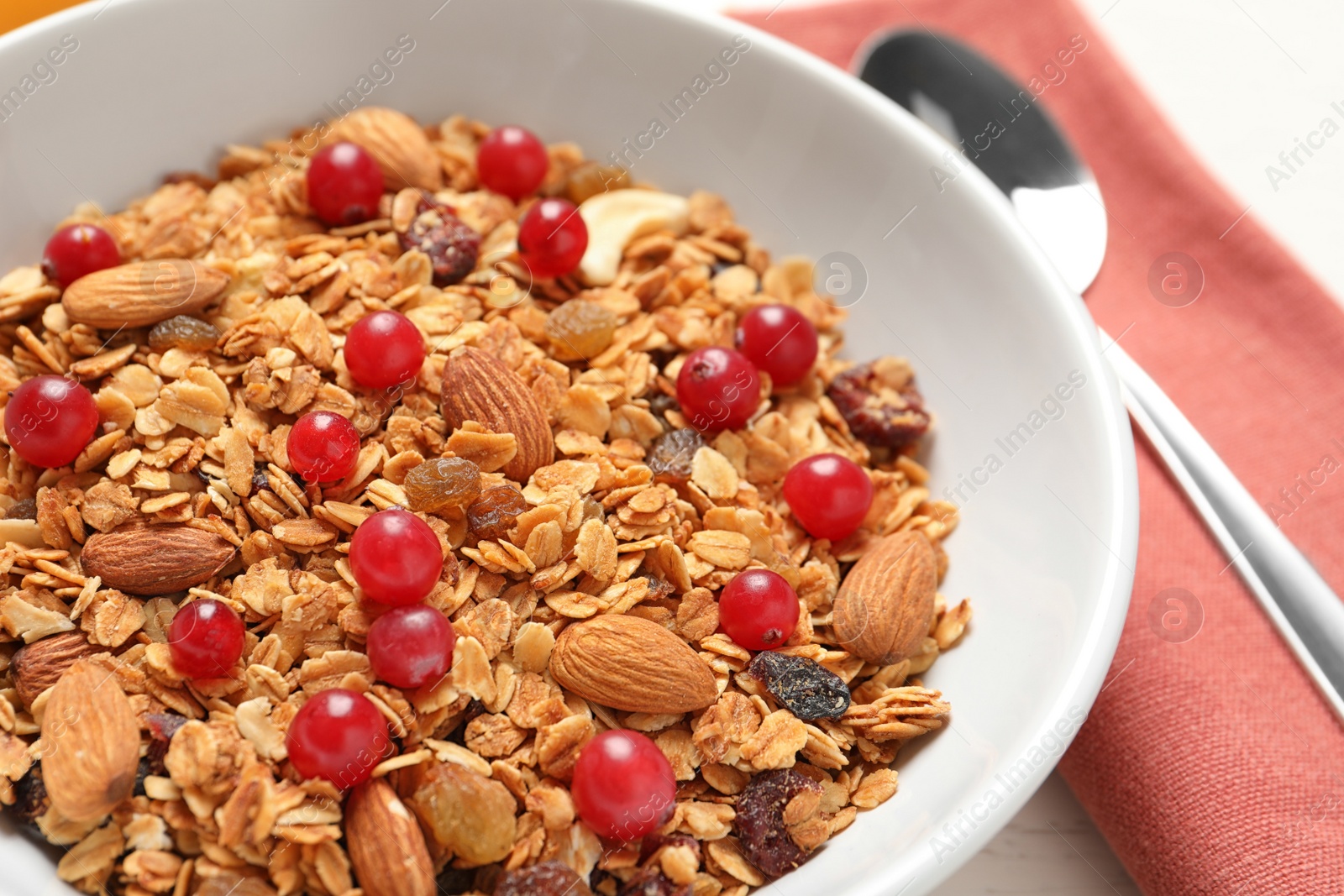 Photo of Tasty granola with cranberries on table, closeup. Healthy breakfast
