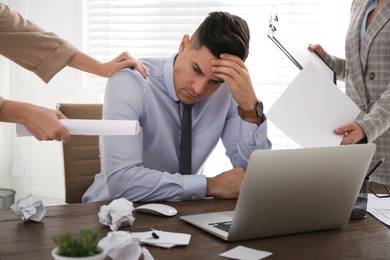 Photo of Businessman stressing out at workplace in office