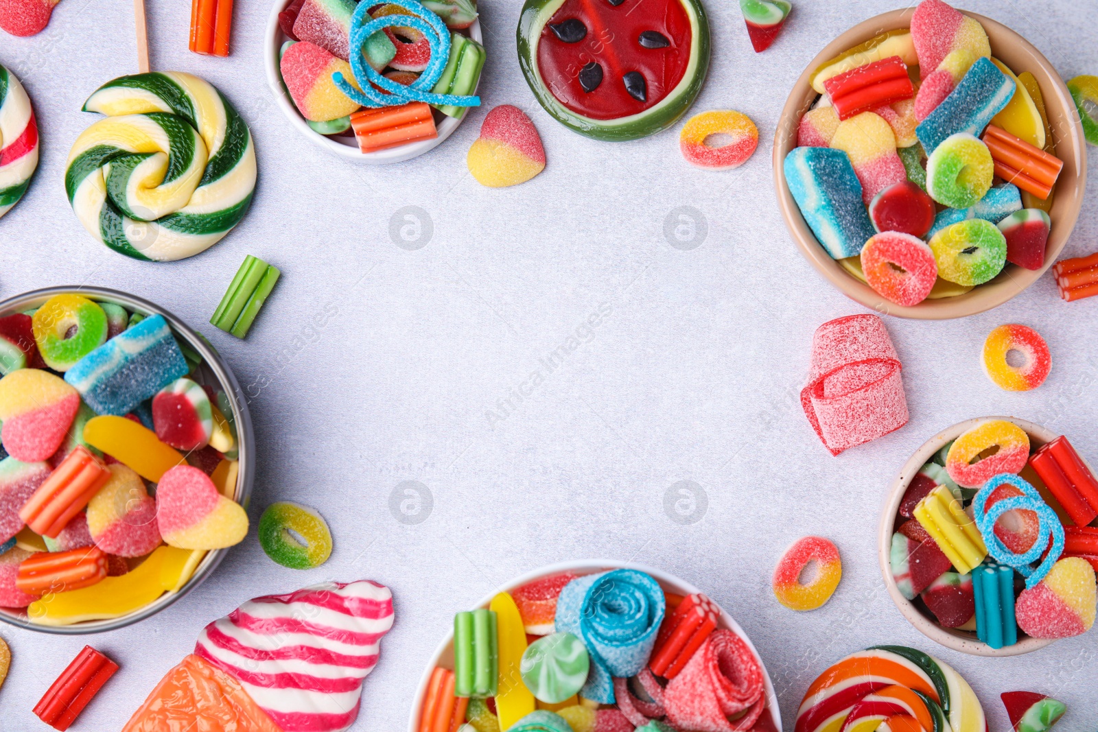 Photo of Frame of many tasty colorful jelly candies on white table, flat lay. Space for text