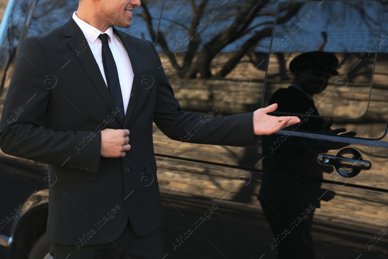 Photo of Professional driver near luxury car, closeup. Chauffeur service