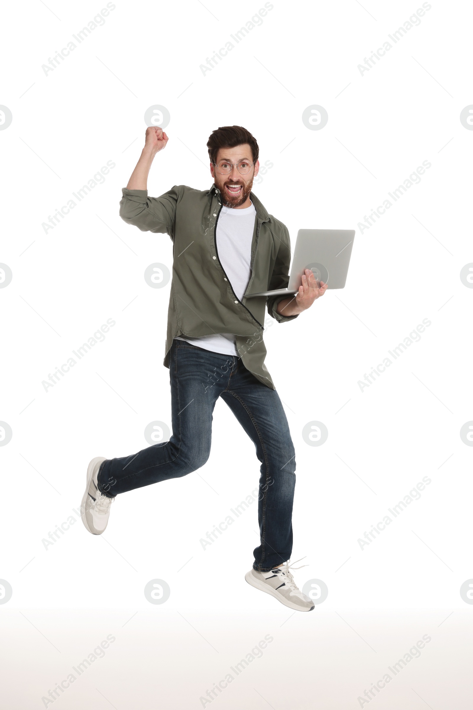 Photo of Happy man with laptop jumping on white background