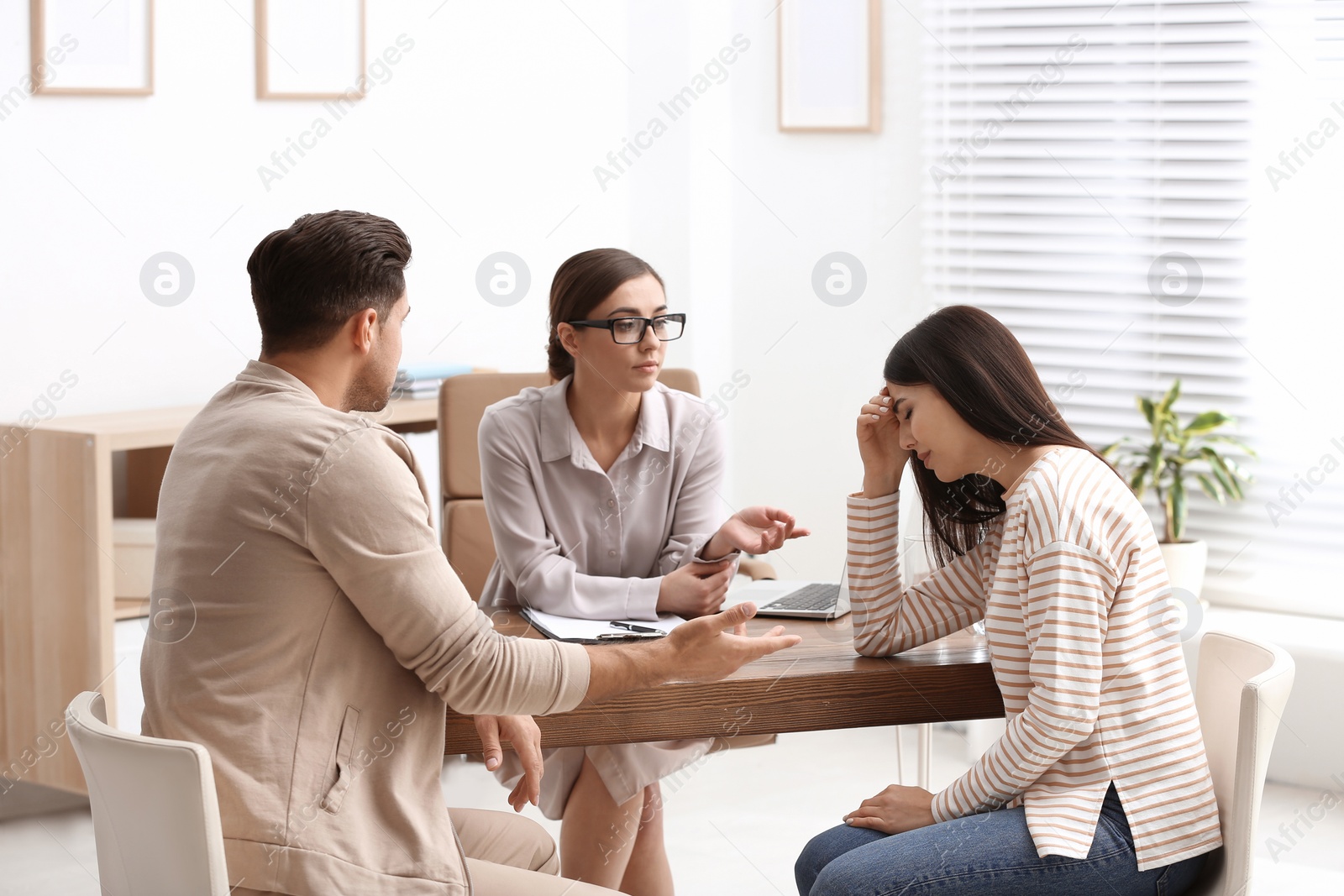 Photo of Professional psychologist working with couple in office