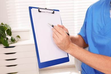 Photo of Doctor with clipboard in clinic, closeup. Patient consultation