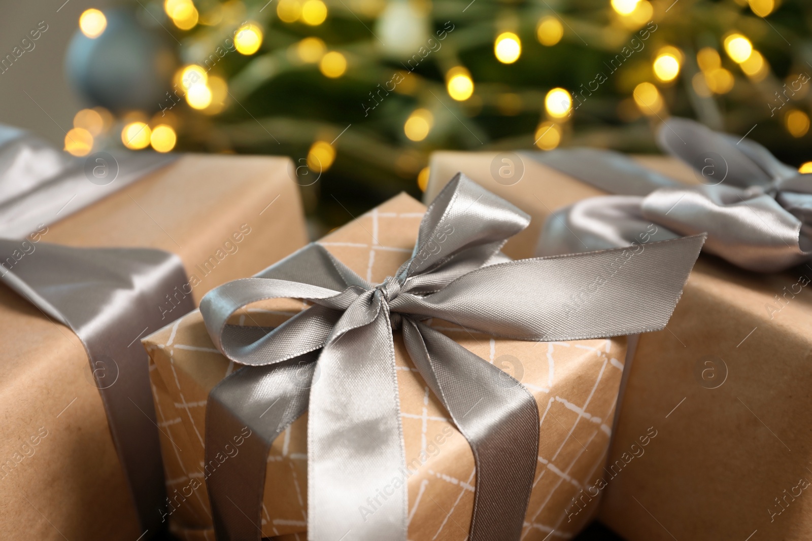 Photo of Beautiful gift boxes and blurred Christmas tree on background