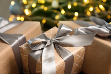 Photo of Beautiful gift boxes and blurred Christmas tree on background