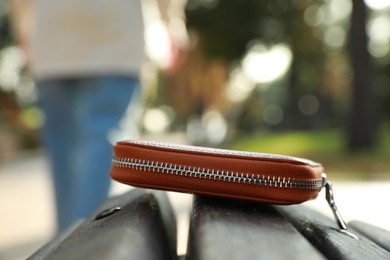 Photo of Woman lost her purse on wooden surface outdoors, selective focus. Space for text