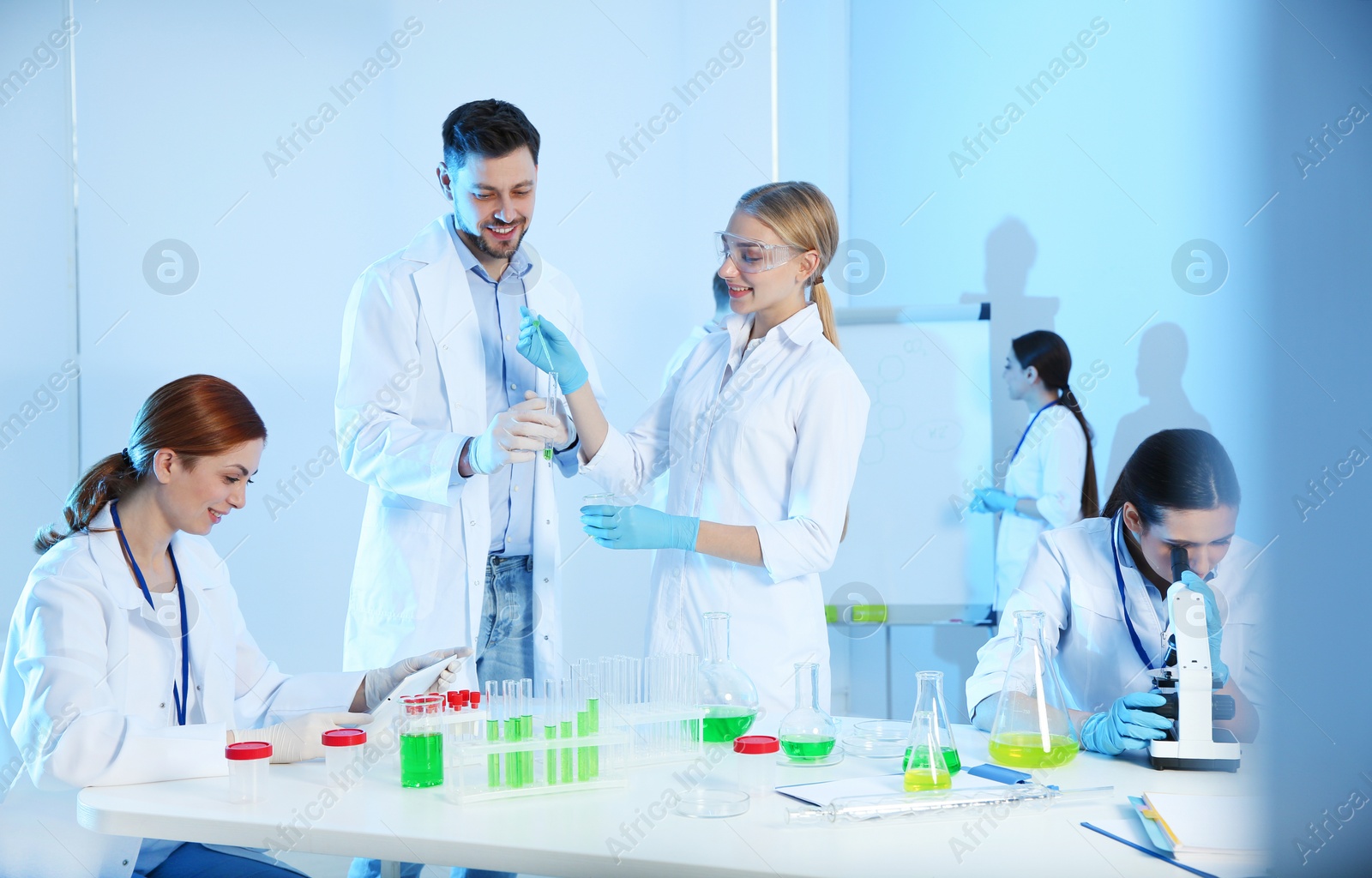 Photo of Group of scientists working in modern chemistry laboratory