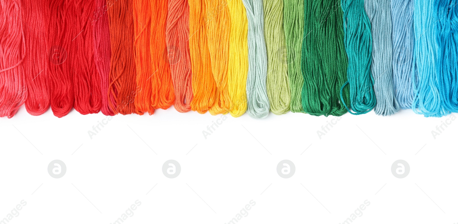 Photo of Set of colorful embroidery threads on white background, top view