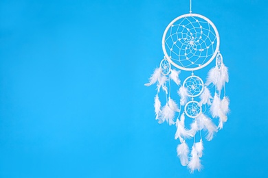 Beautiful handmade dream catcher on light blue background. Space for text