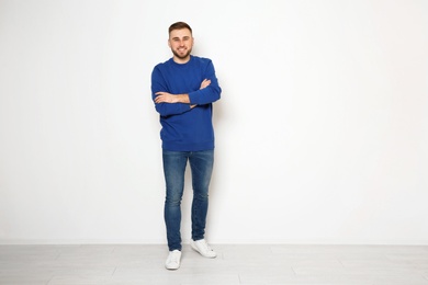 Photo of Full length portrait of handsome man against white wall. Space for text