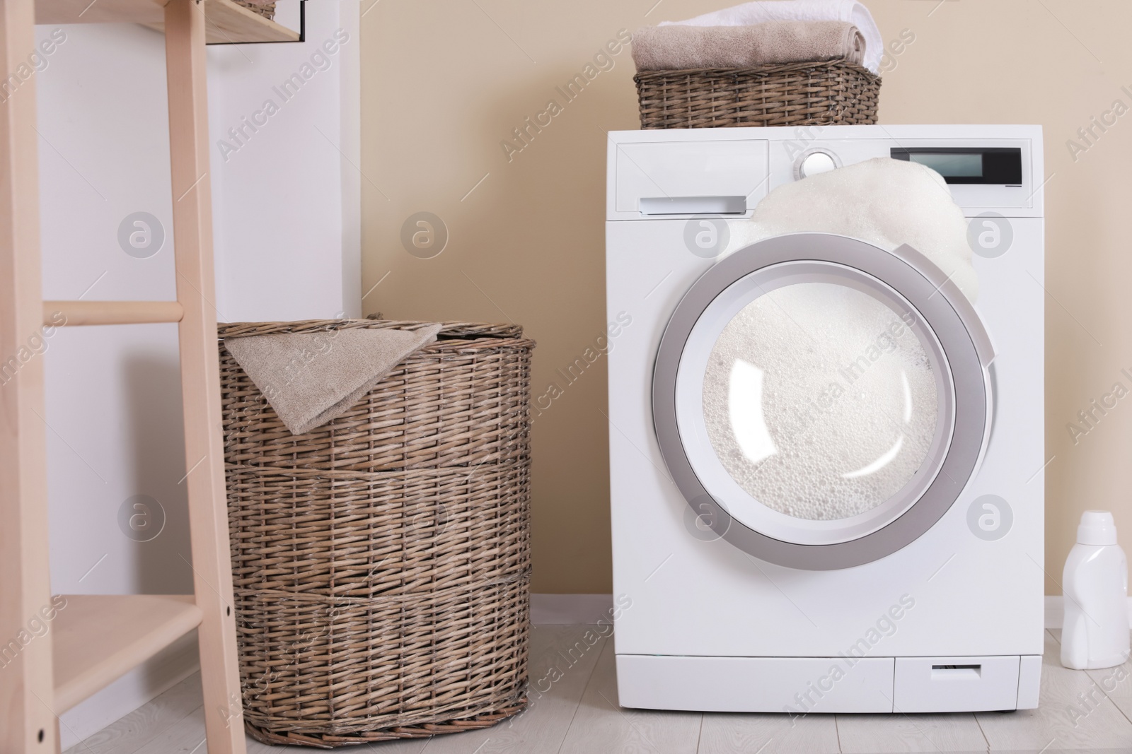 Image of Foam coming out from broken washing machine during laundering in room