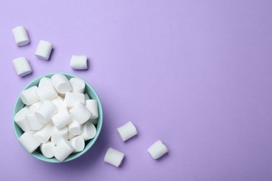 Delicious puffy marshmallows on lilac background, flat lay. Space for text