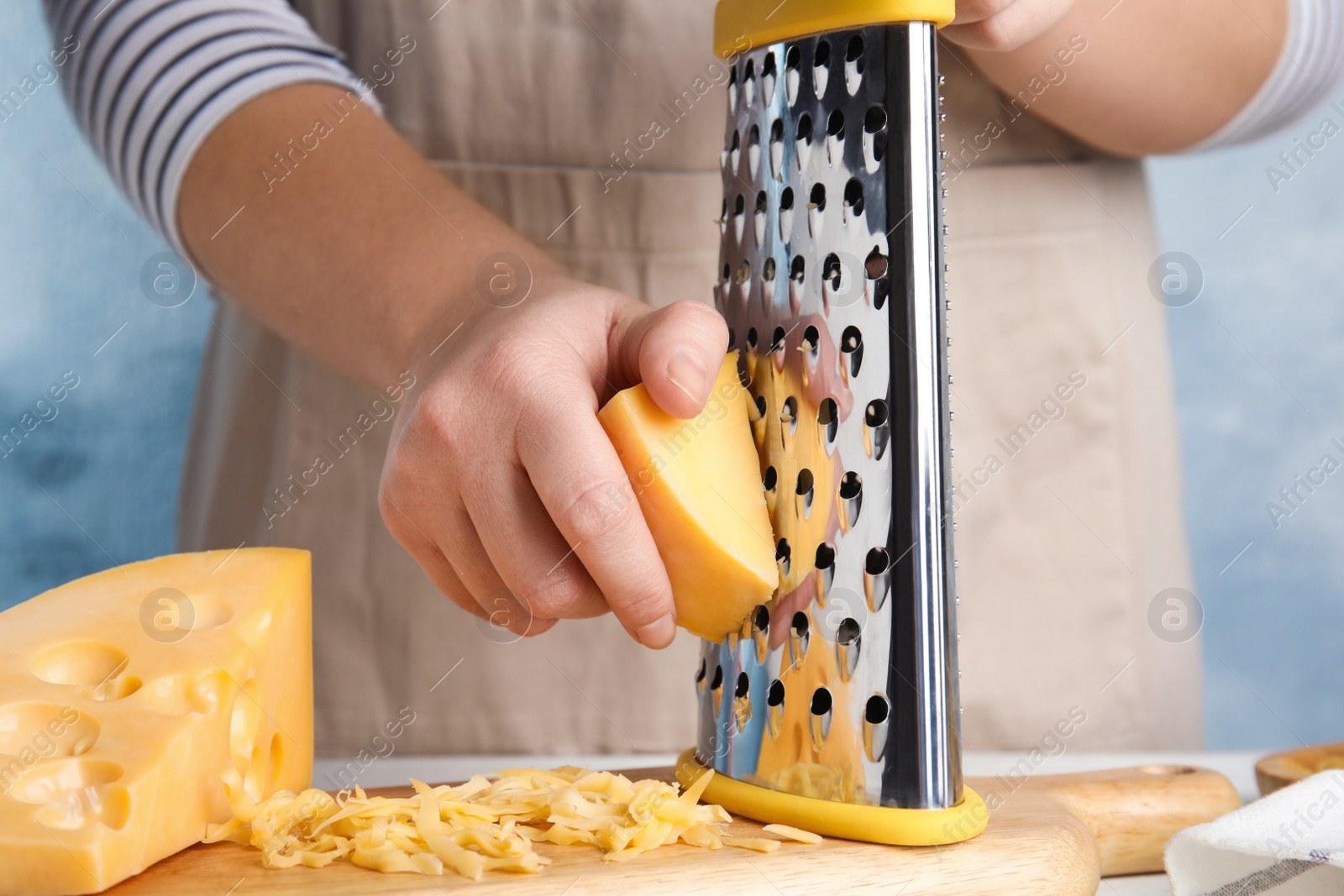 Photo of Woman grating fresh cheese at table, closeup