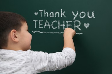 Image of Cute little boy written phrase Thank You Teacher on green chalkboard
