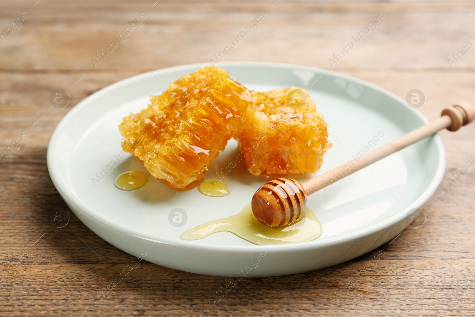 Photo of Tasty honey and combs on wooden table