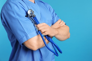 Photo of Medical assistant with stethoscope on color background, closeup. Space for text