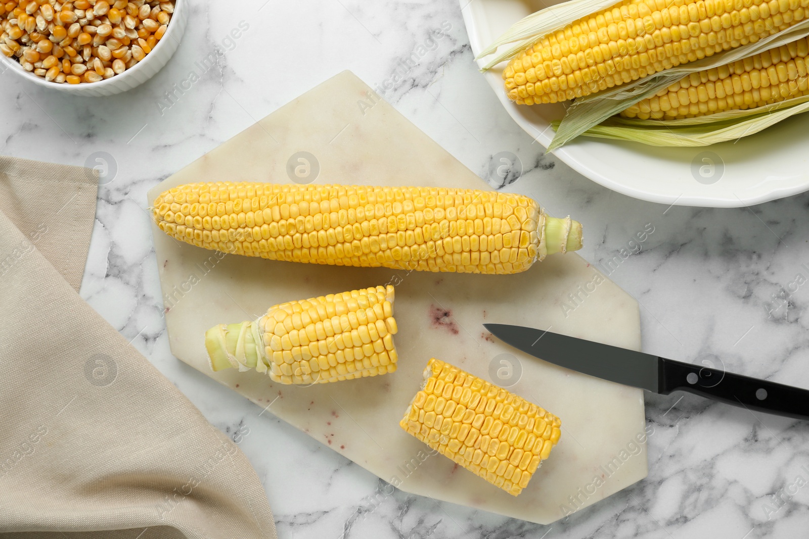Photo of Tasty fresh corn cobs on white marble table, flat lay