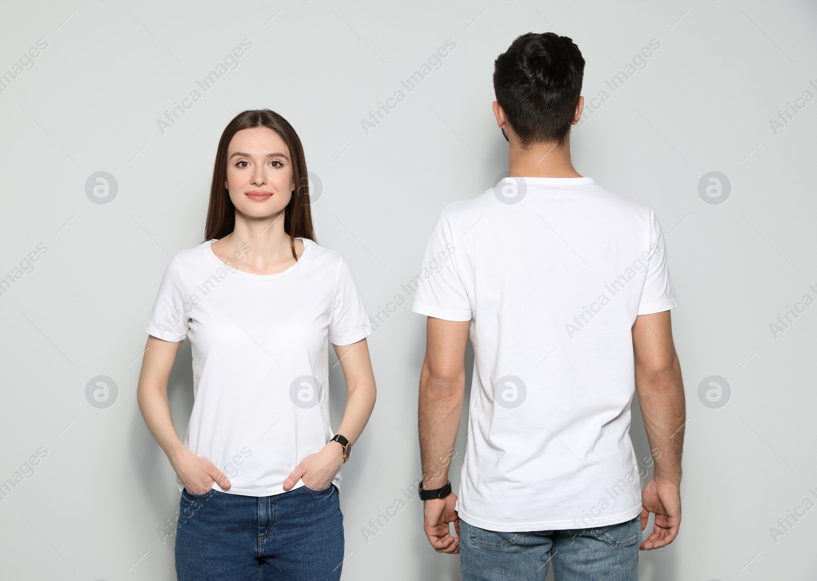 Photo of Young people in t-shirts on light background. Mock up for design