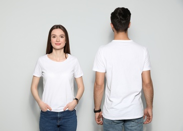 Photo of Young people in t-shirts on light background. Mock up for design