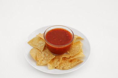 Tasty salsa sauce and tortilla chips on white background