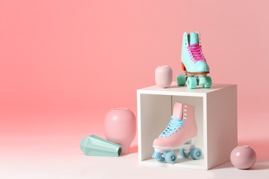 Photo of Composition with vintage roller skates and storage cube on color background. Space for text