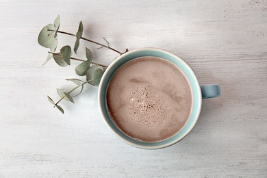 Cup with delicious hot cocoa drink on table, top view