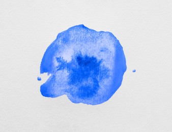 Photo of Blot of light blue ink on white background, top view