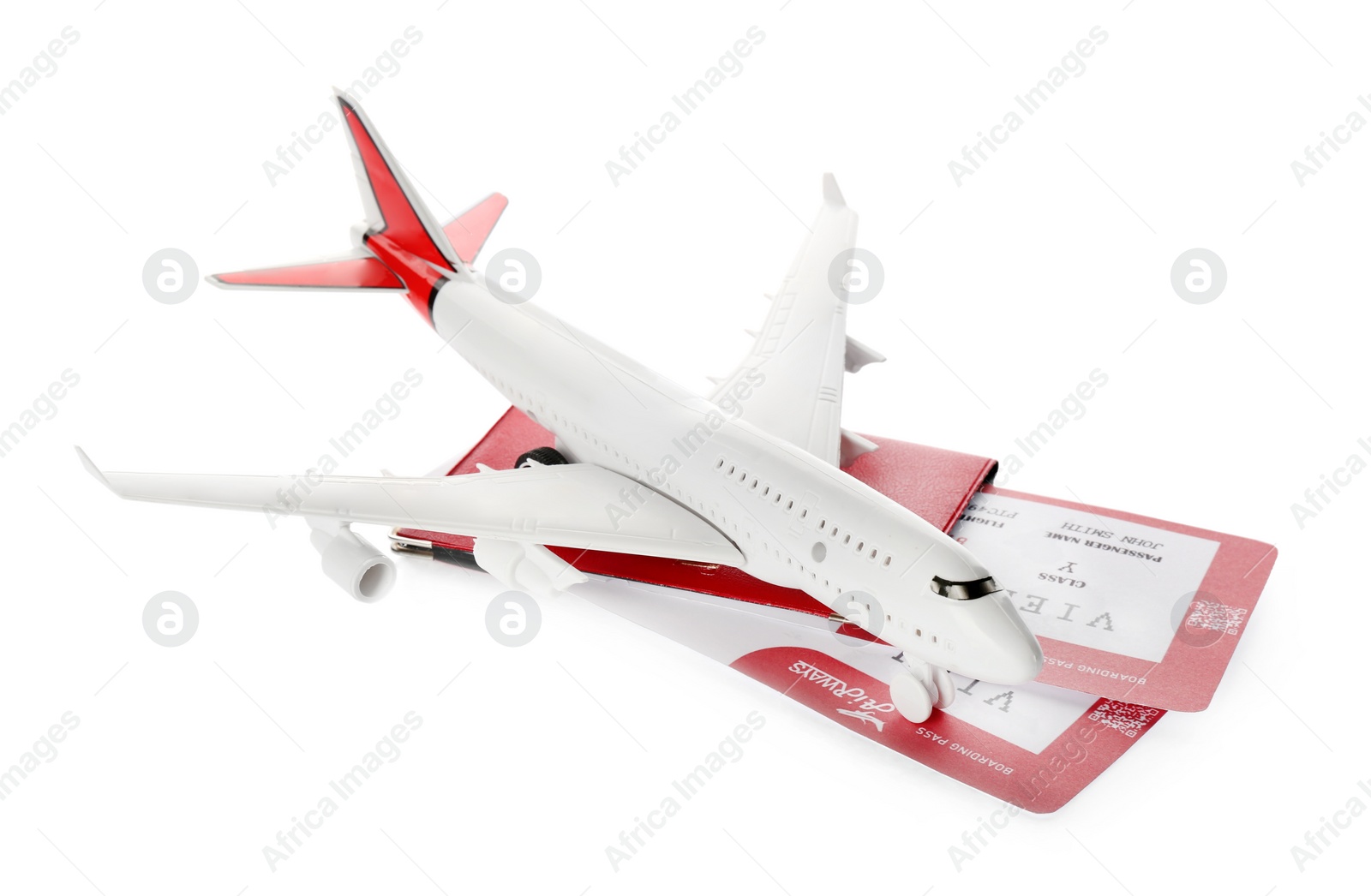 Photo of Toy airplane and passport with tickets on white background
