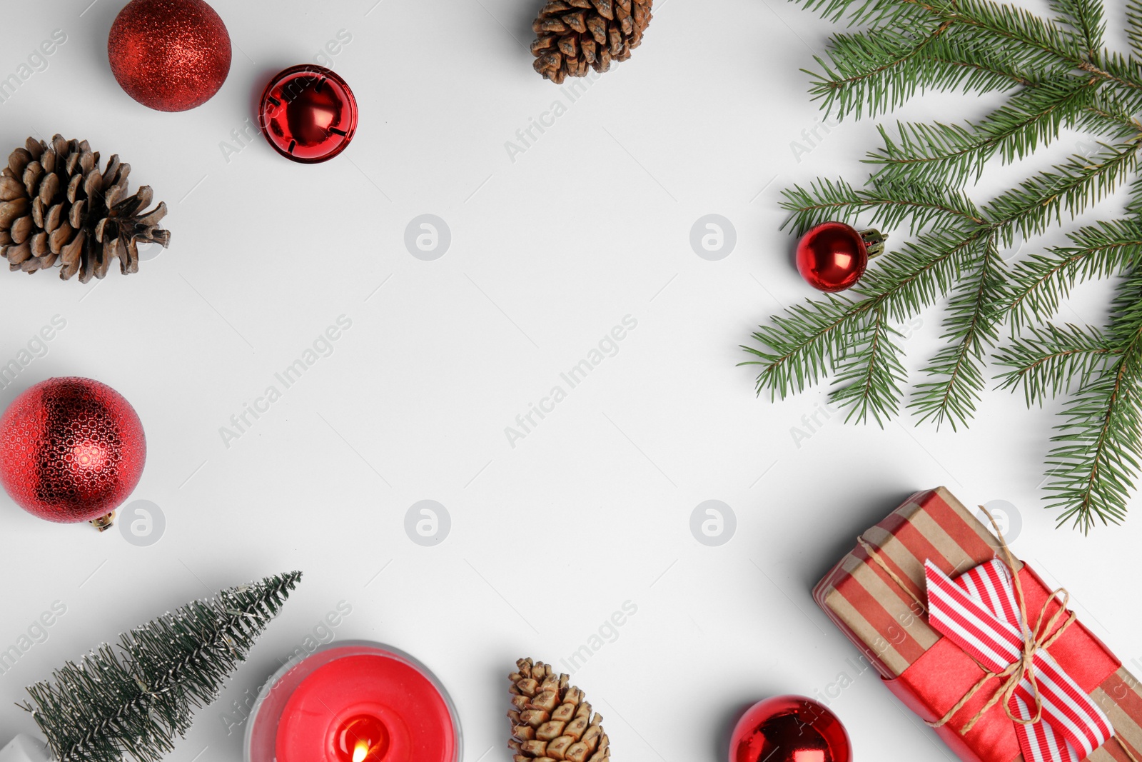 Photo of Christmas greeting card with space for text. Flat lay composition of fir tree branches and festive decor on white background