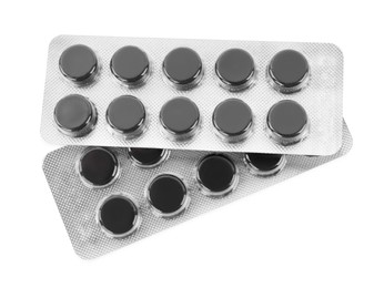 Photo of Activated charcoal pills in blisters on white background, top view. Potent sorbent