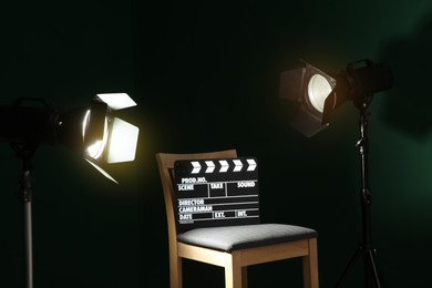 Photo of Chair with clapperboard under spotlight in studio