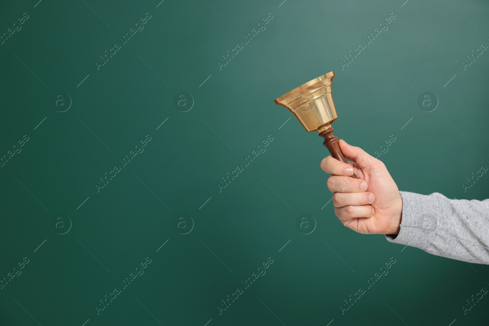 Photo of Teacher with school bell near chalkboard, closeup. Space for text