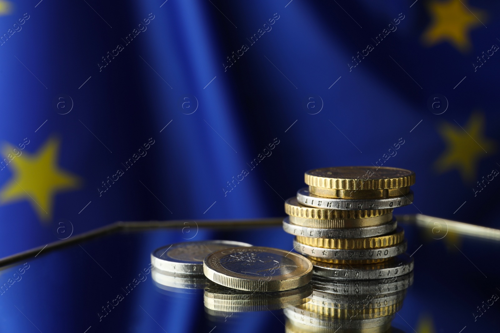 Photo of Coins on table against European Union flag, space for text