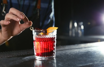 Barman making Red Russian cocktail at counter in pub, closeup. Space for text