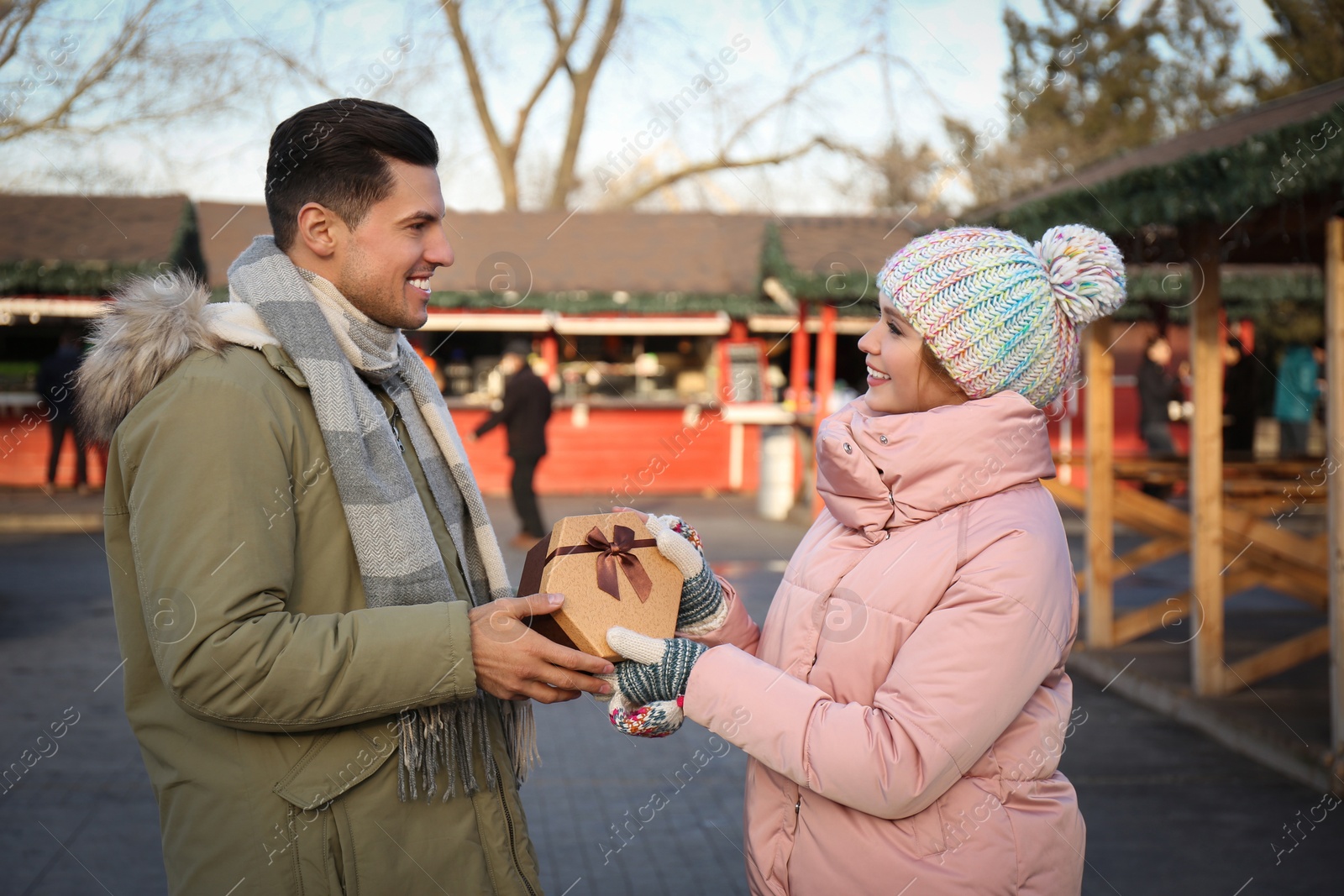 Photo of Happy couple with Christmas gift at winter fair