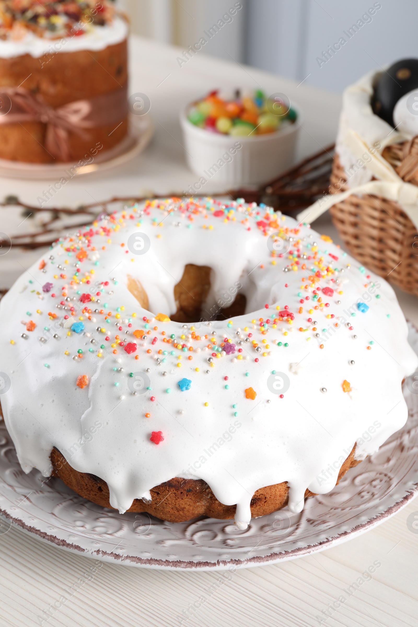 Photo of Delicious Easter cake decorated with sprinkles on white wooden table